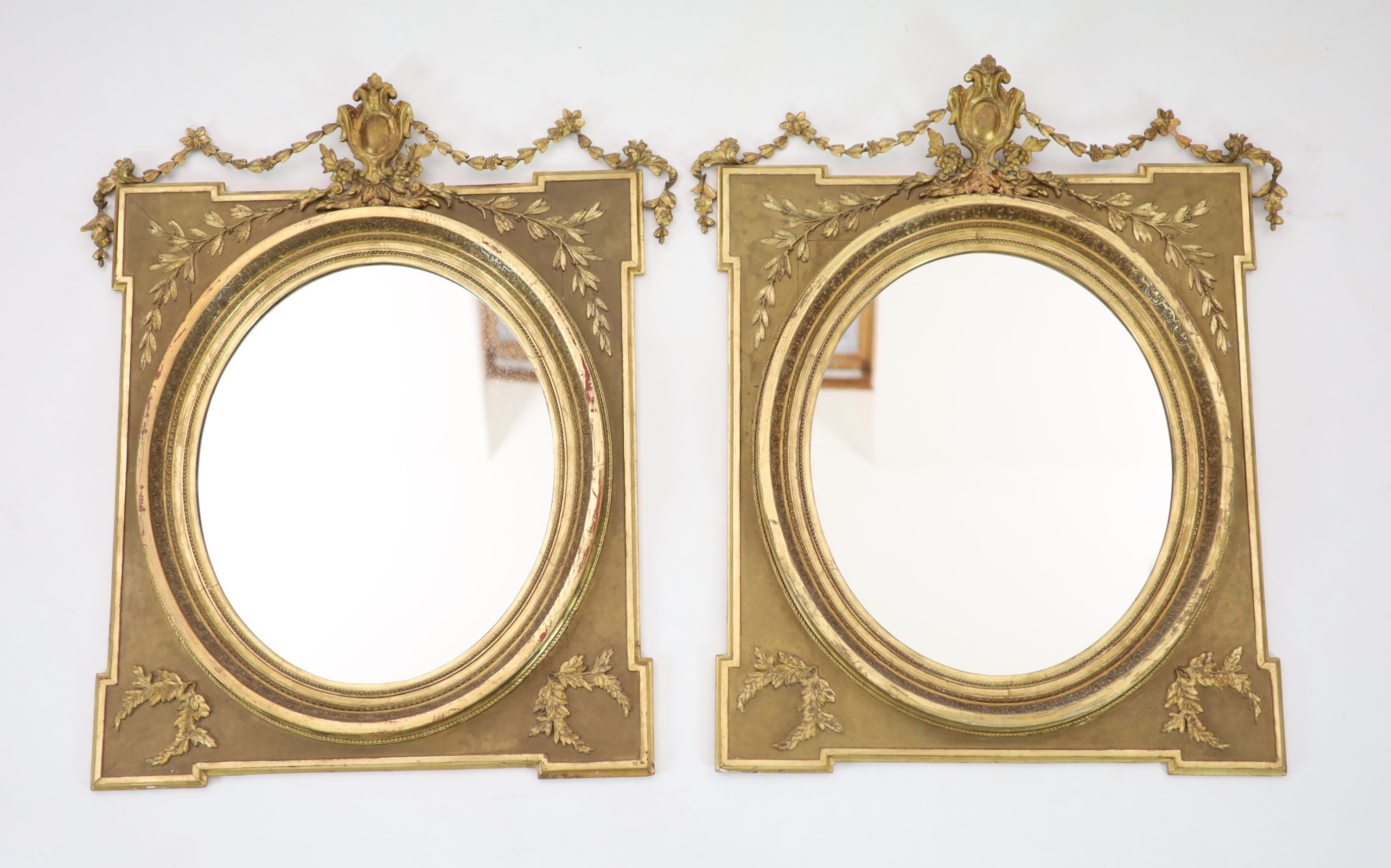 A pair of giltwood wall mirrors, of square form with oval plates, width 85cm, height 98cm